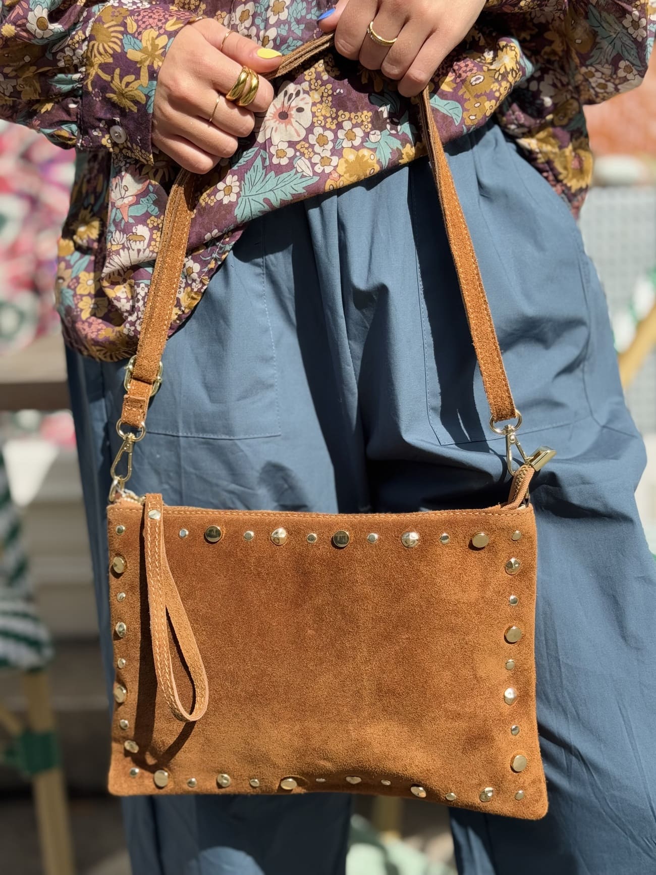 gros plan sur un sac en daim pochette en daim clouté