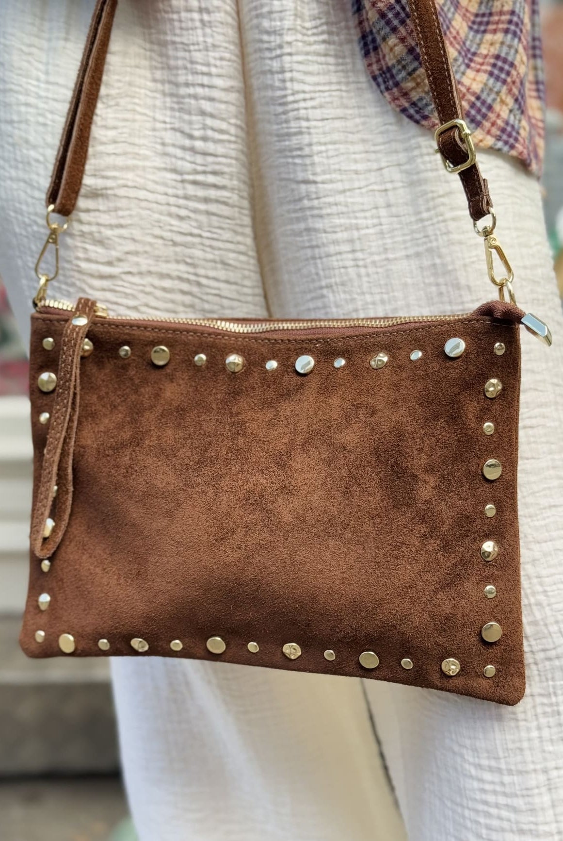 Gros plan sur le sac en daim - pochette marron orné de clous dorés