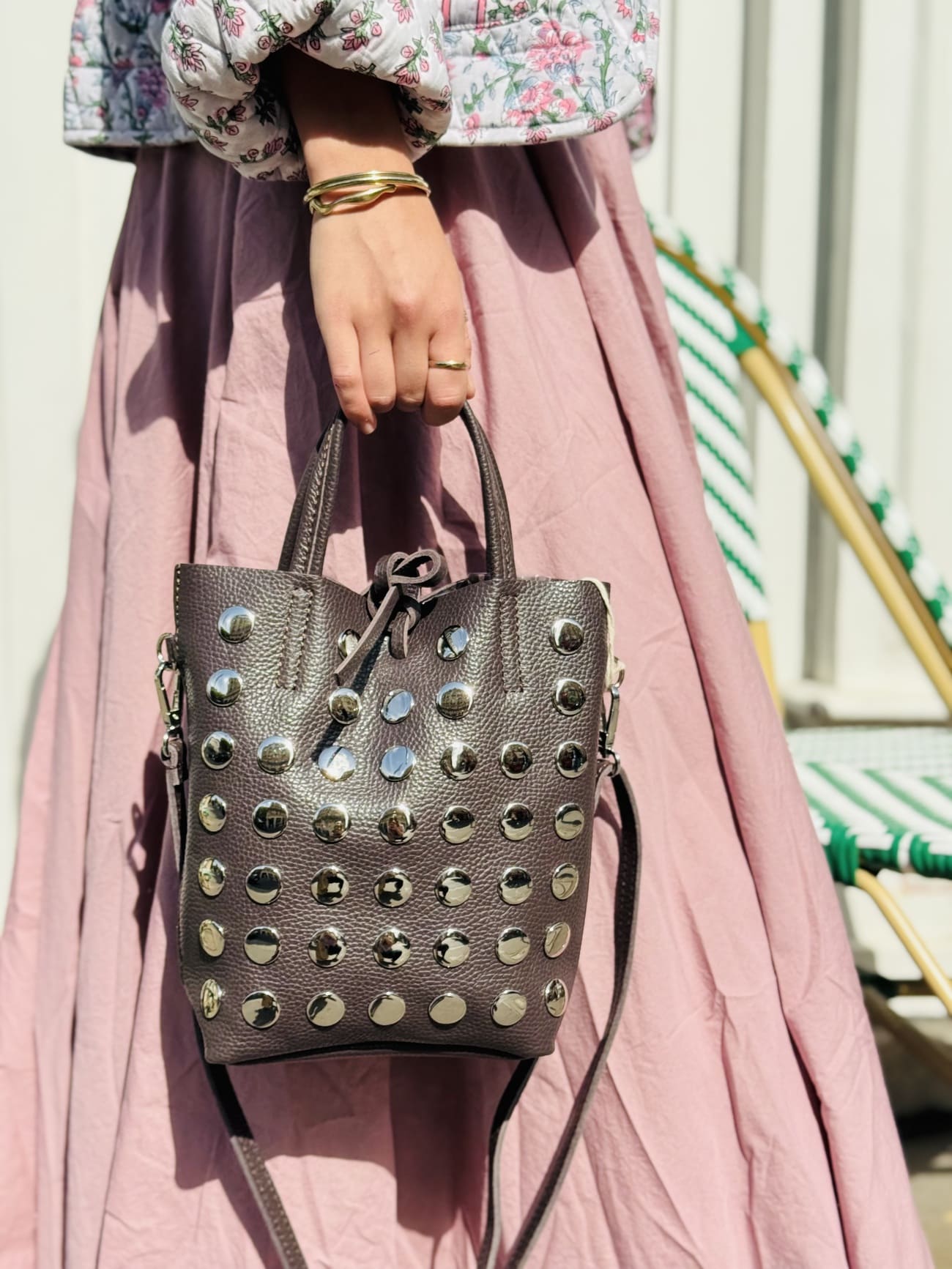 Plan serré sur le sac seau marron aux clous oversize.