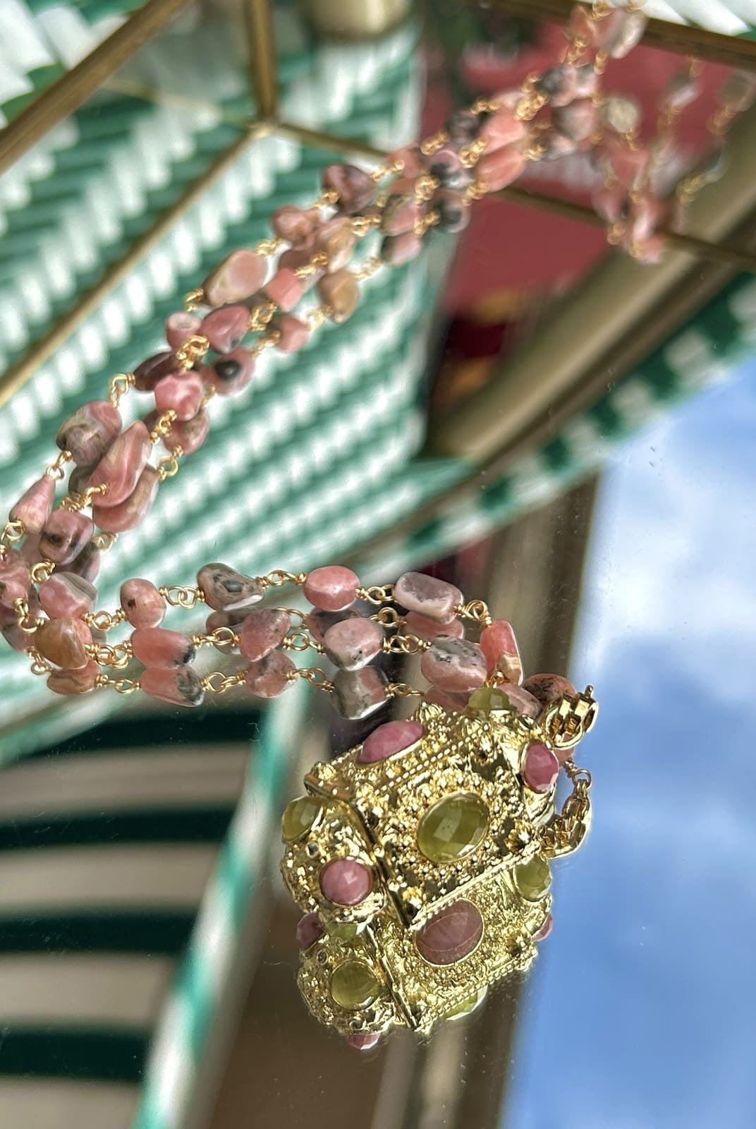 Gros plan sur le sautoir talisman avec perles roses délicates