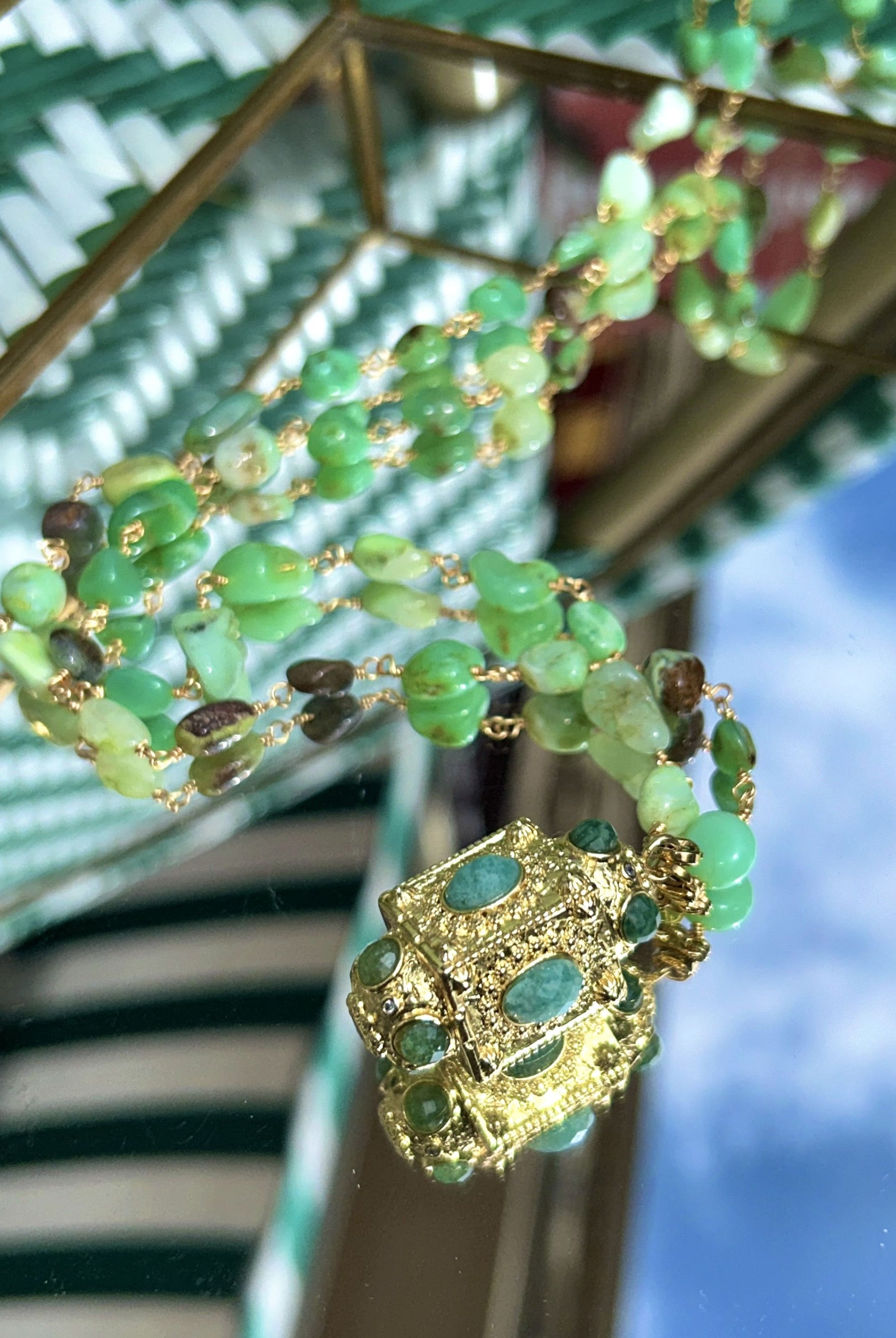 Gros plan sur le sautoir talisman vert avec perles d'agate et pendentif