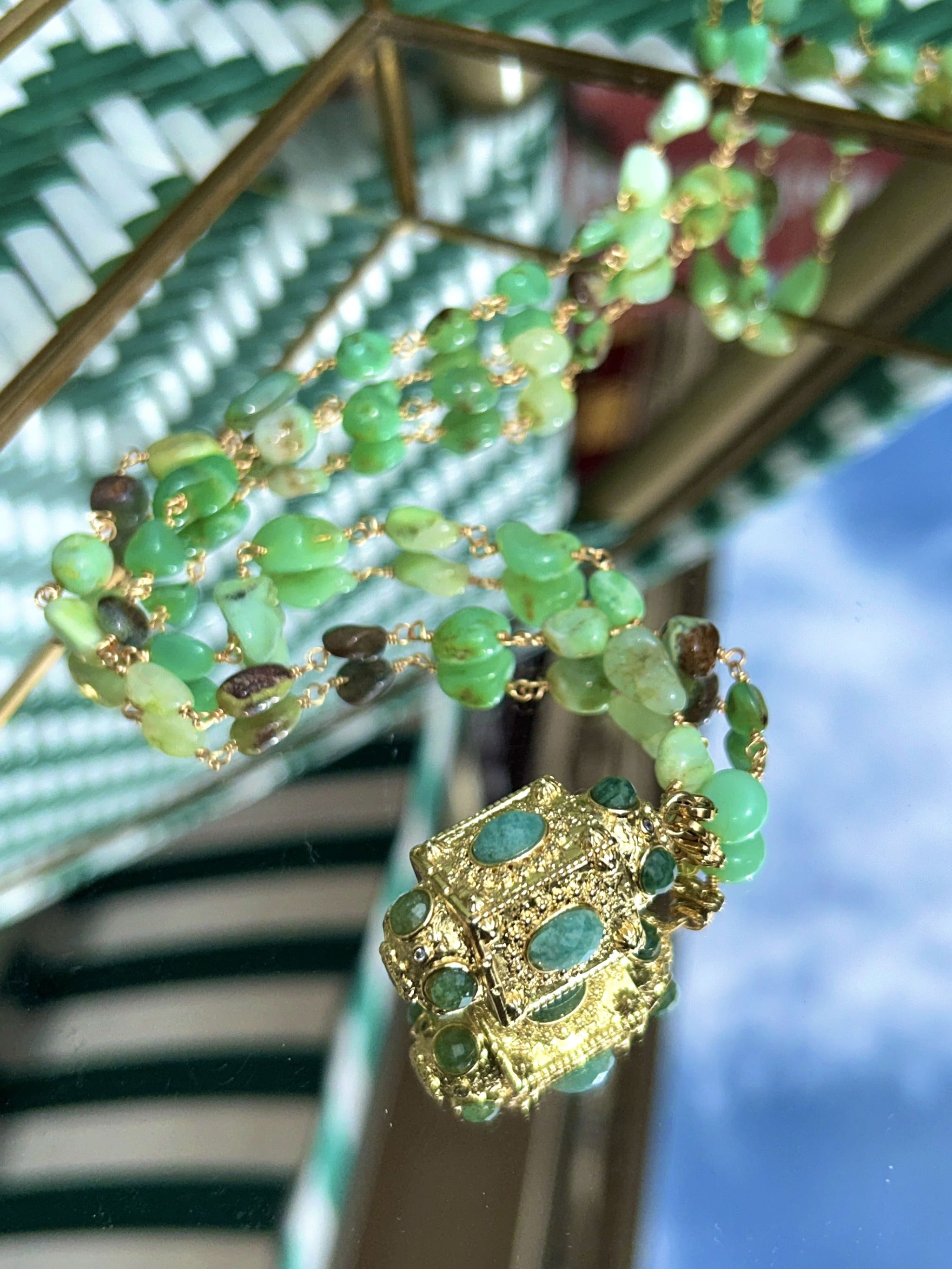 Gros plan sur le sautoir talisman vert avec perles d'agate et pendentif