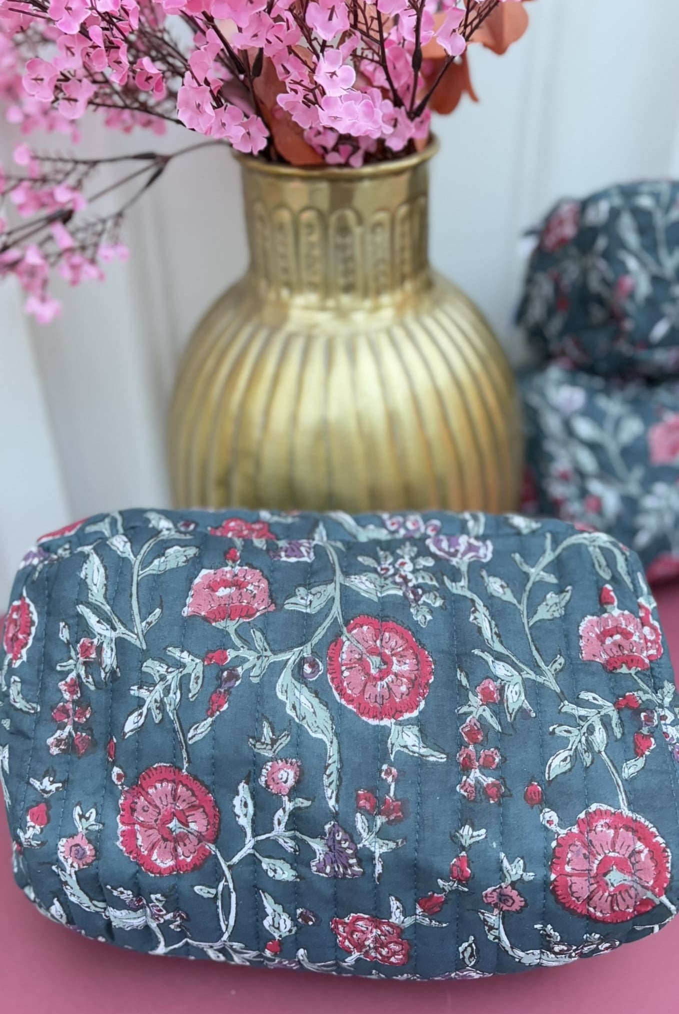 Détail du motif fleuri de la trousse en coton matelasse verte