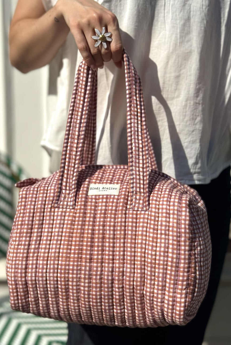 Femme portant un sac matelassé à imprimé carreaux