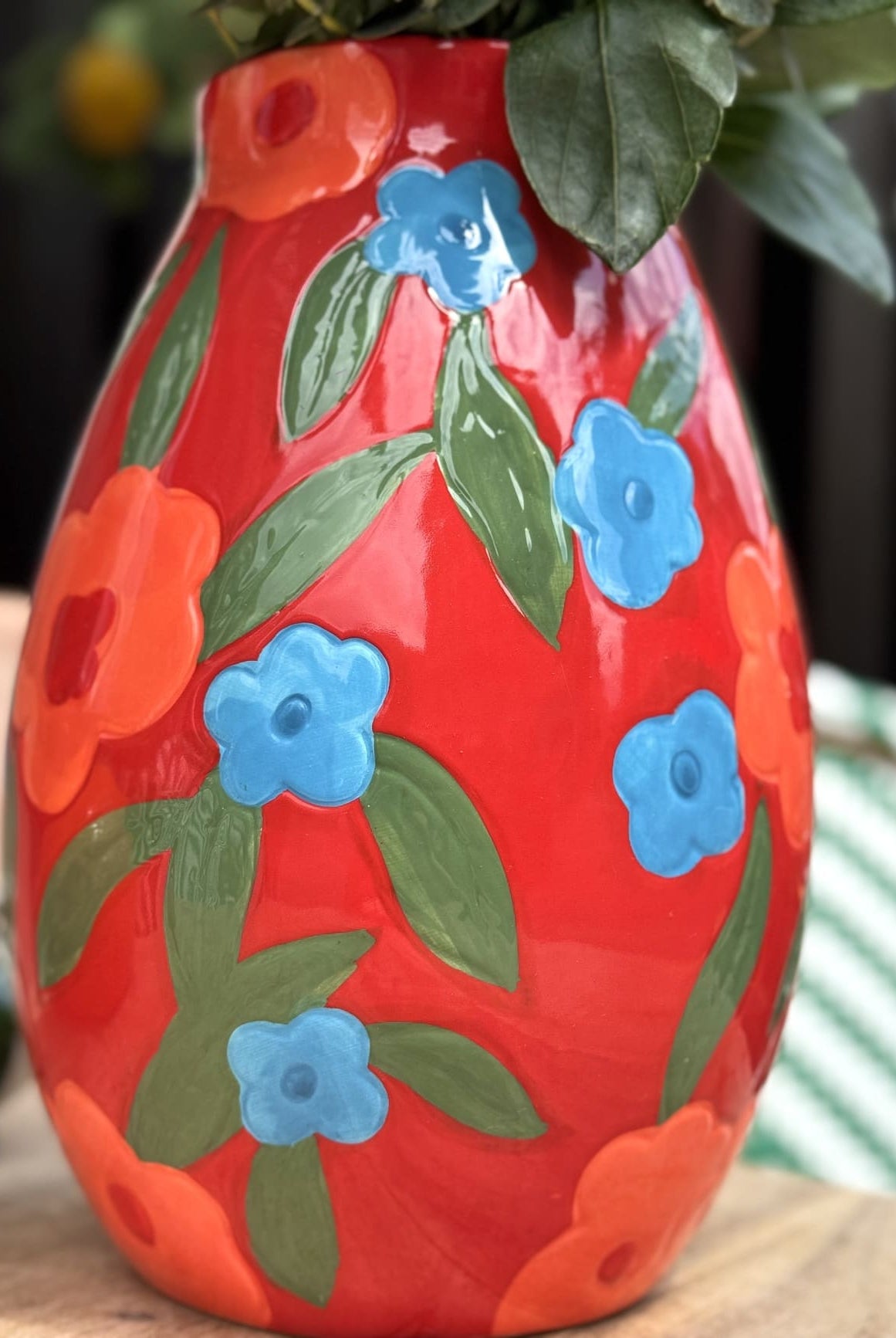 Détail de fleurs colorées peintes à la main sur vase rouge