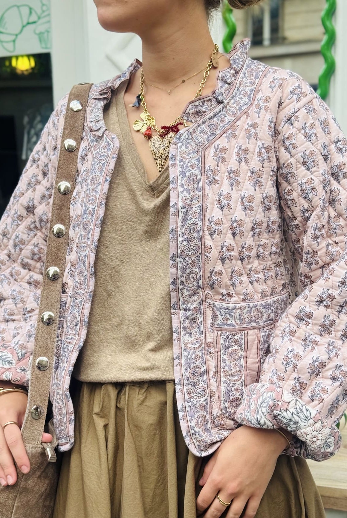 Plan américain sur une femme portant la veste matelassée en coton rose et beige pour femme