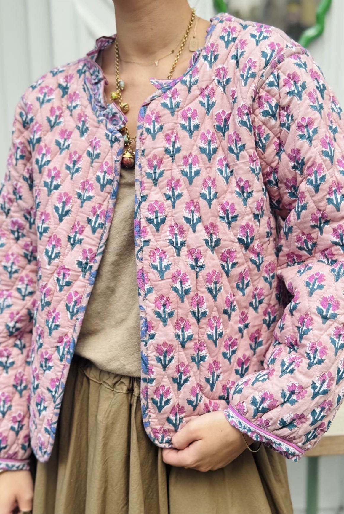 Détail de l'imprimé de petites fleurs vertes et roses sur fond rose