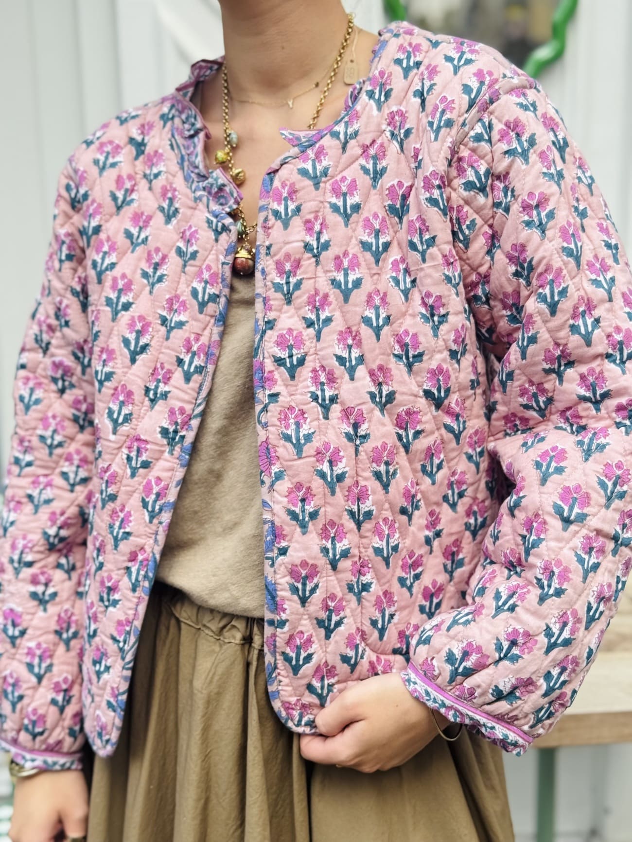 Détail de l'imprimé de petites fleurs vertes et roses sur fond rose