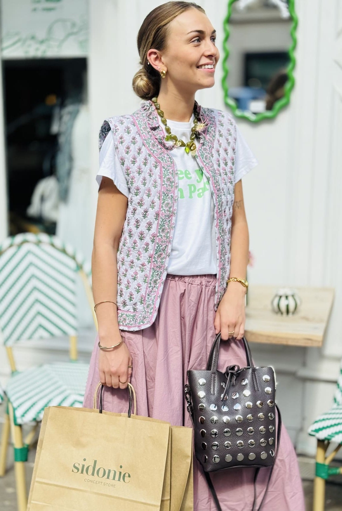 Veste matelassée sans manche rose et verte portée sur une jupe