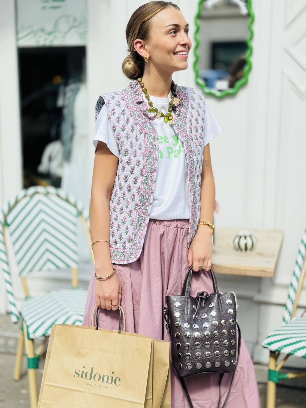 Veste matelassée sans manche rose et verte portée sur une jupe