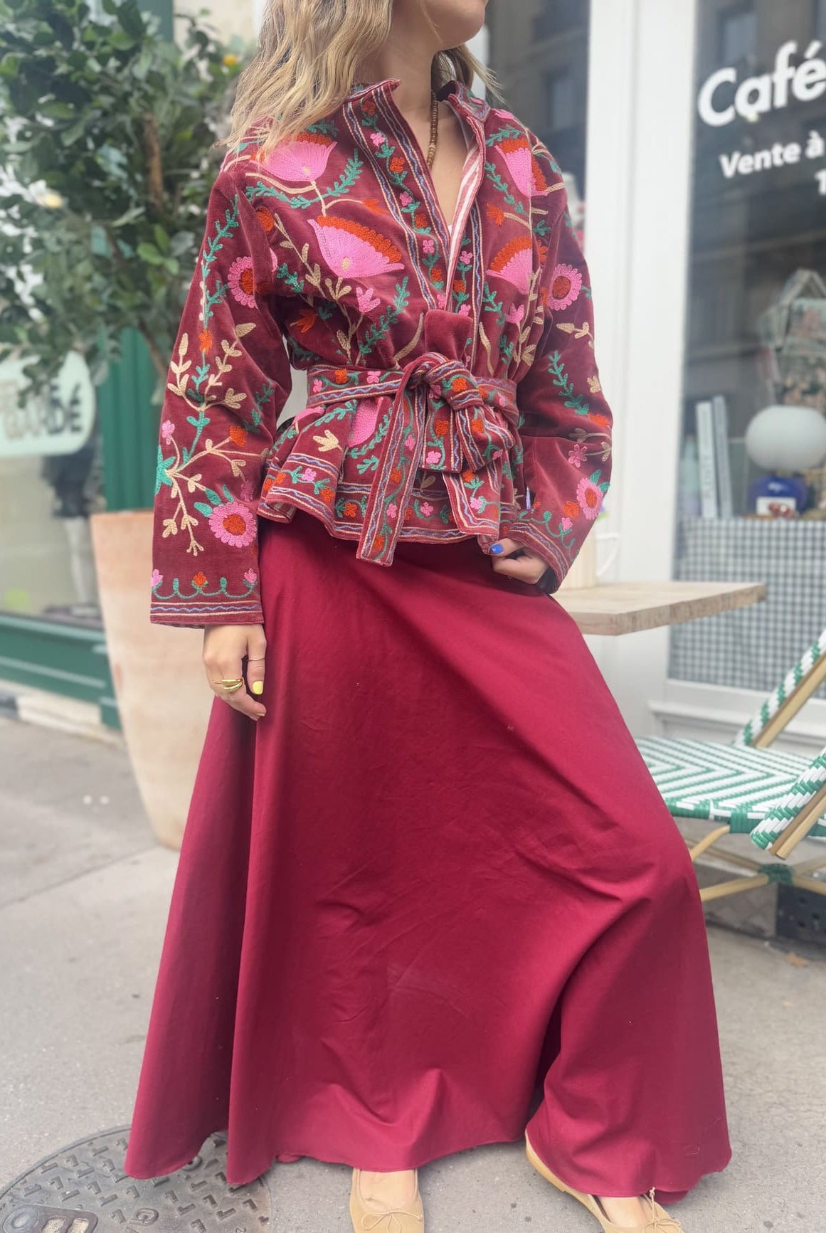 Femme portant la veste bordeaux en velours brodé sur une jupe longue