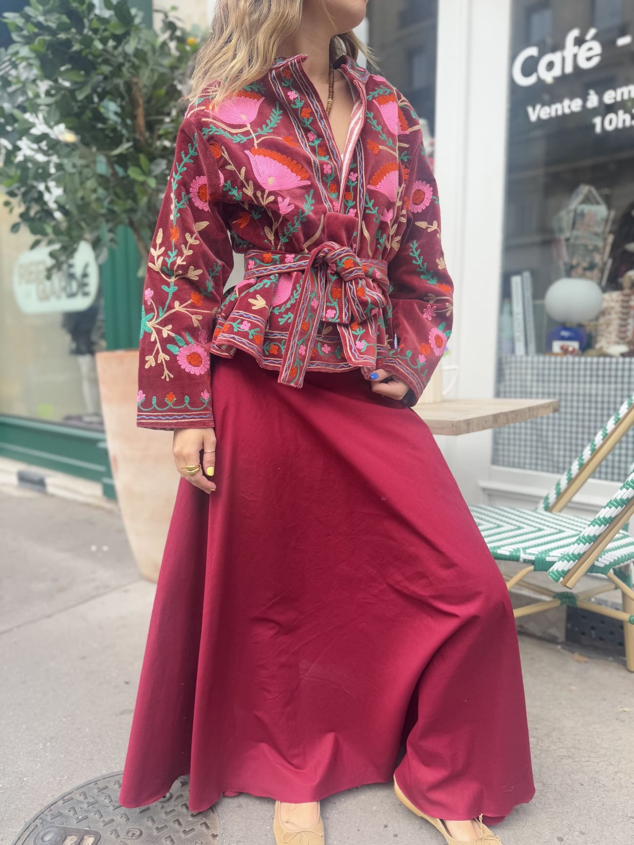 Femme portant la veste bordeaux en velours brodé sur une jupe longue