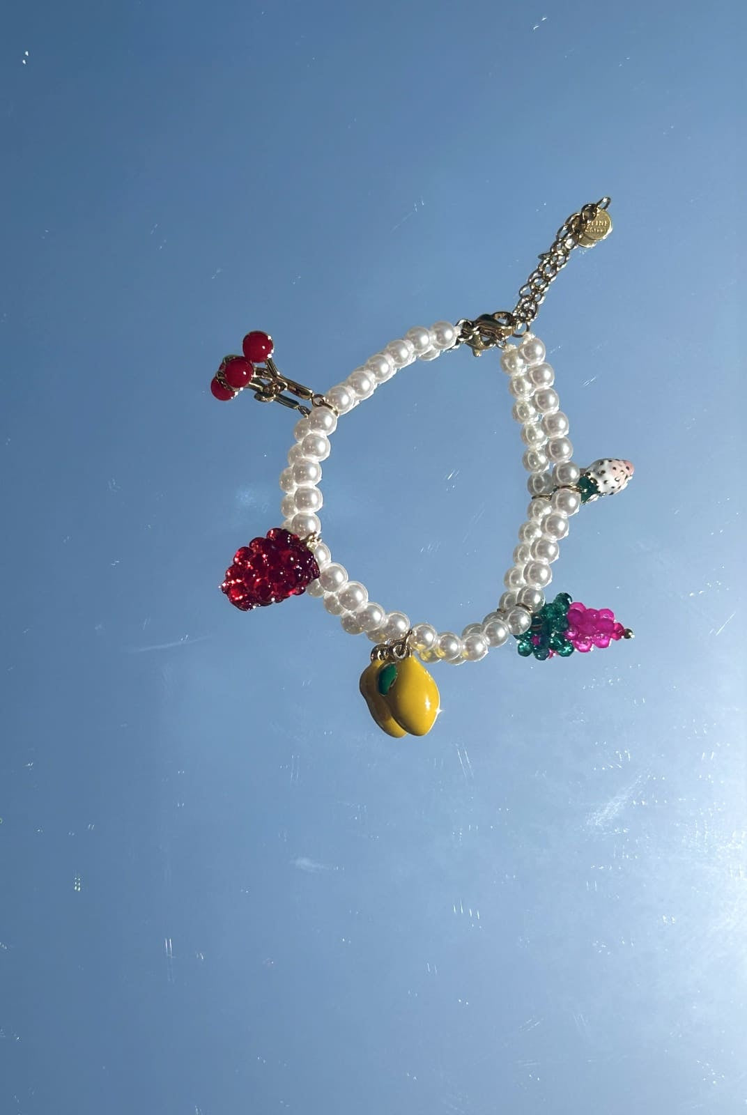 Zoom sur les breloques fruits et perles colorées du bracelet