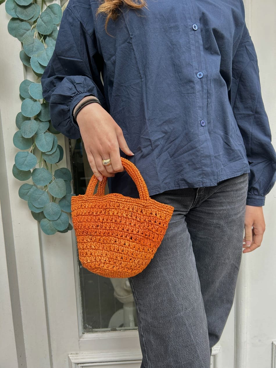 Détail du tressage en raphia du petit panier orange