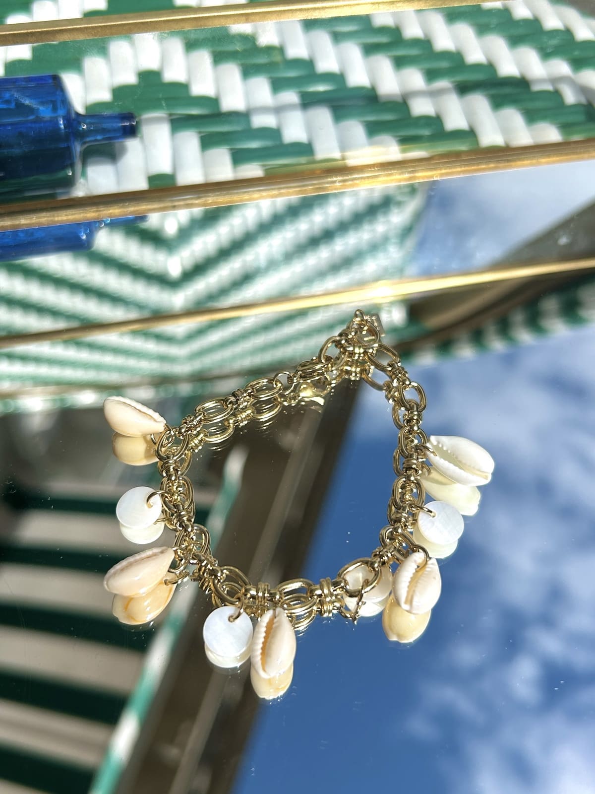 Bracelet breloque avec petits coquillages blancs sur chaîne dorée