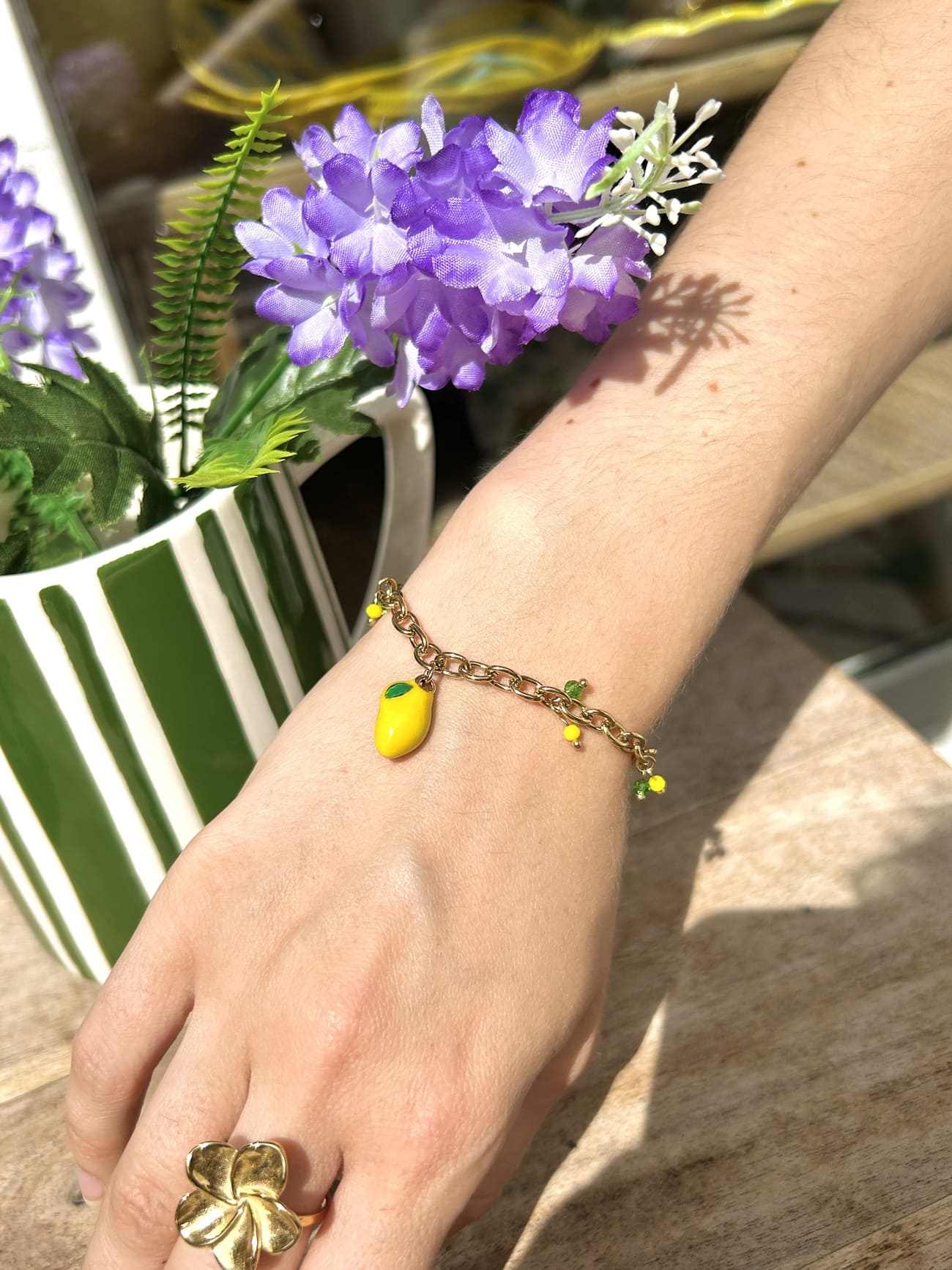 Bracelet breloque citron porté au poignet d’une femme