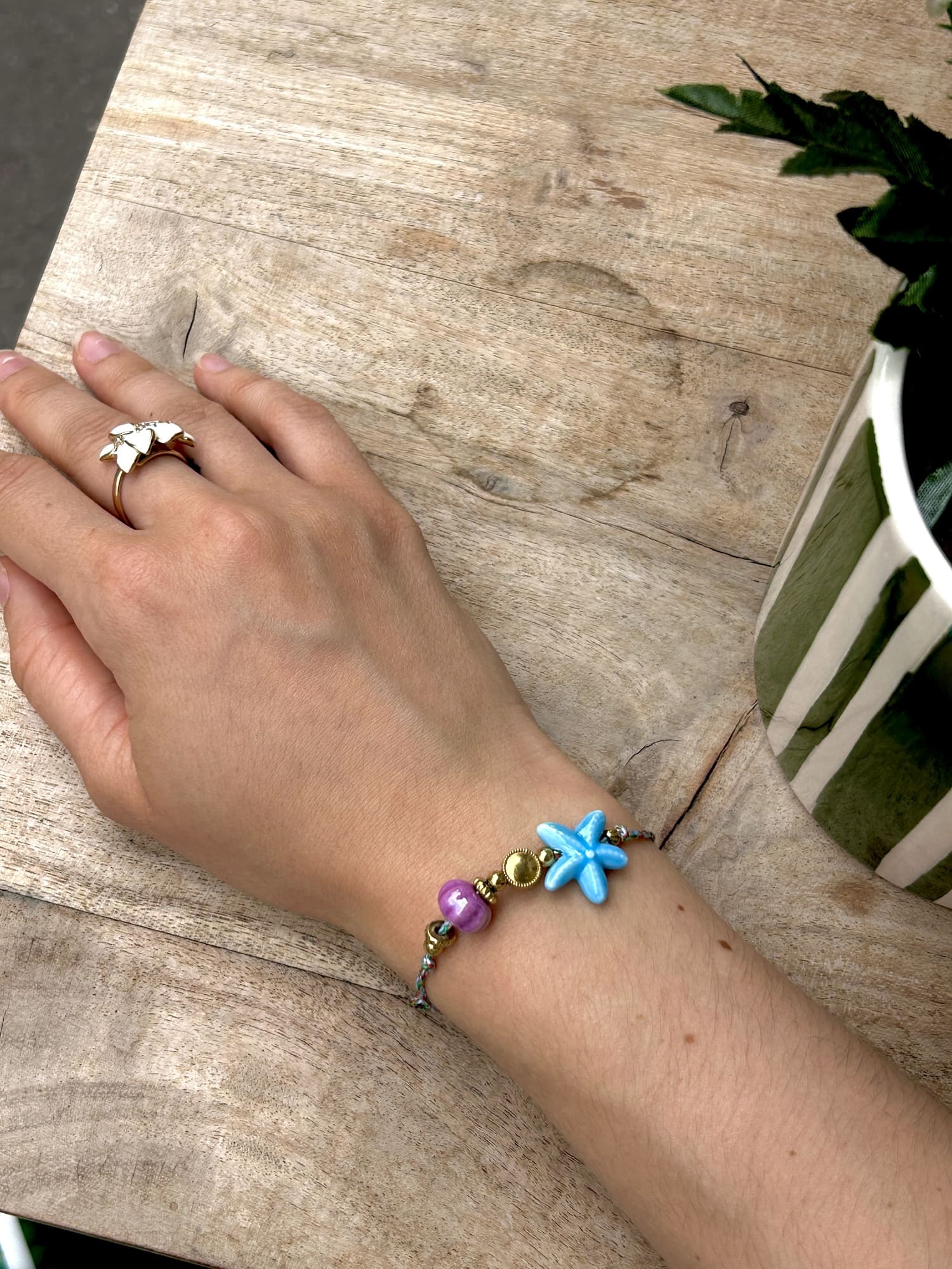 Bracelet perle étoile de mer sur cordon porté au poignet