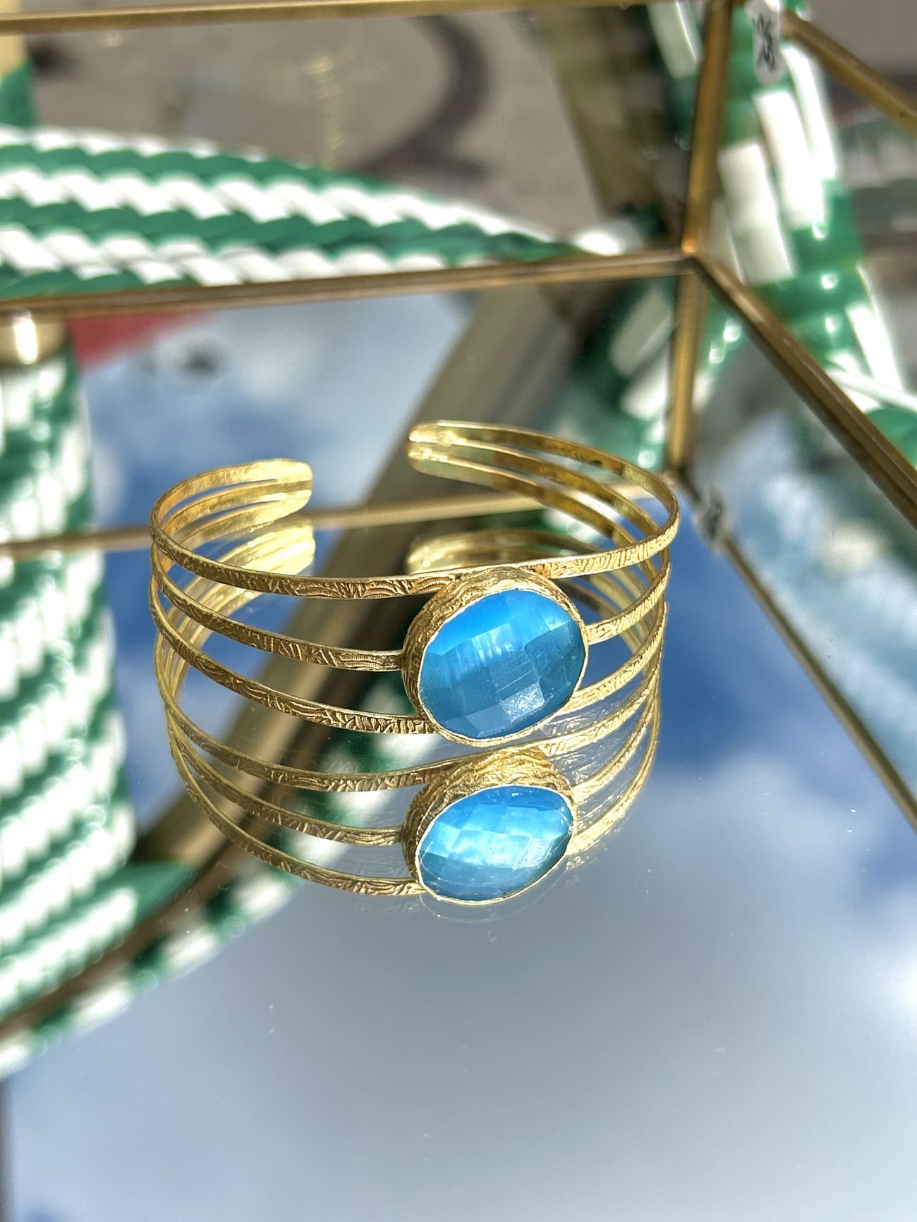 Détail du bracelet en laiton avec arcs élégants et pierre bleue semi-précieuse