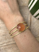 Bracelet manchette en laiton doré et pierre orange au poignet