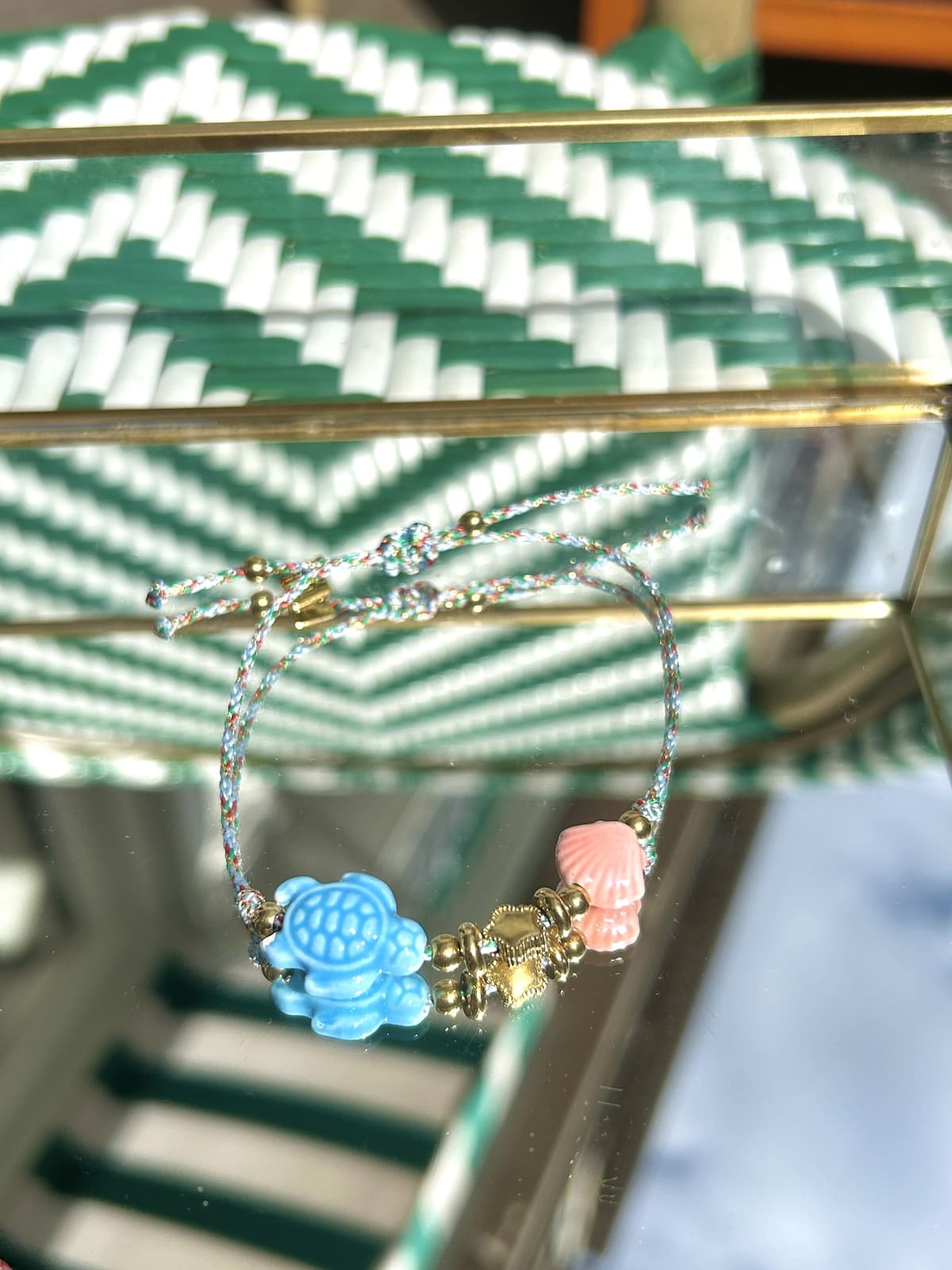 Gros plan sur la breloque tortue bleue et le cordon du bracelet