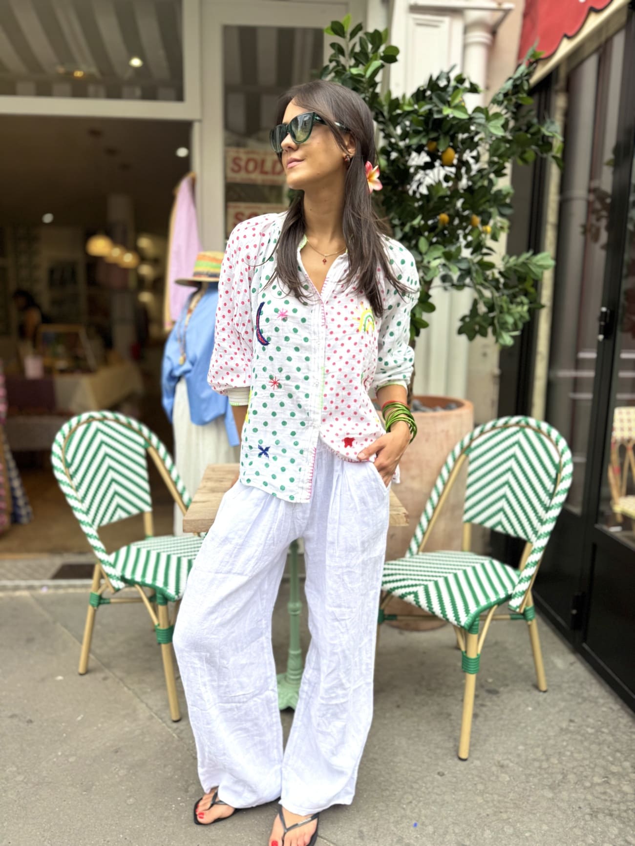 Chemise femme en coton avec des pois rouges et verts sur un pantalon blanc