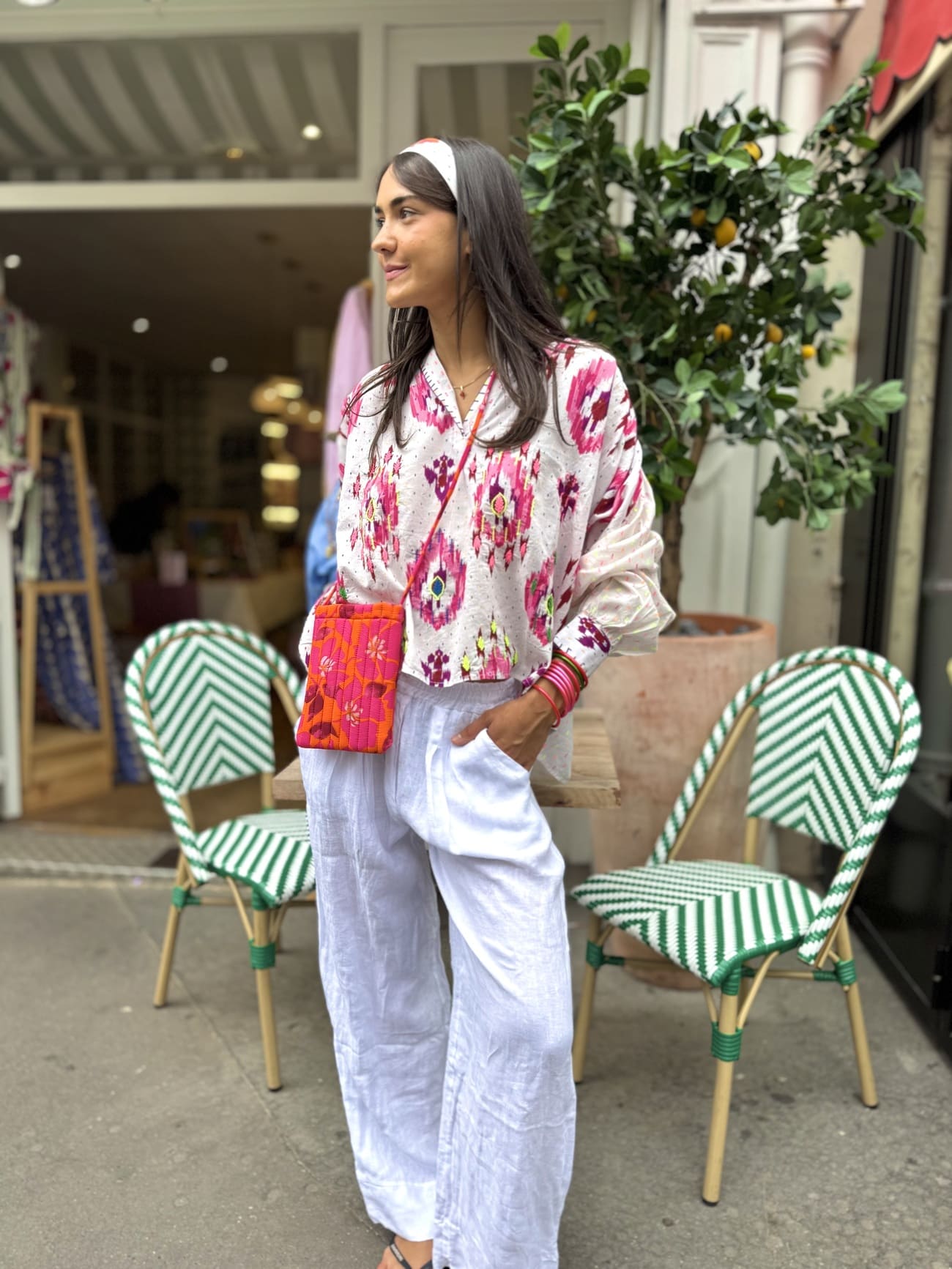 Chemise blanche aux motifs roses portée sur un pantalon blanc