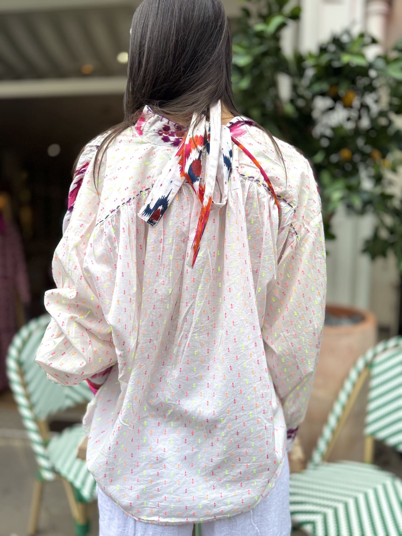 Chemise blanche femme et détail des broderies roses et jaunes dans le dos