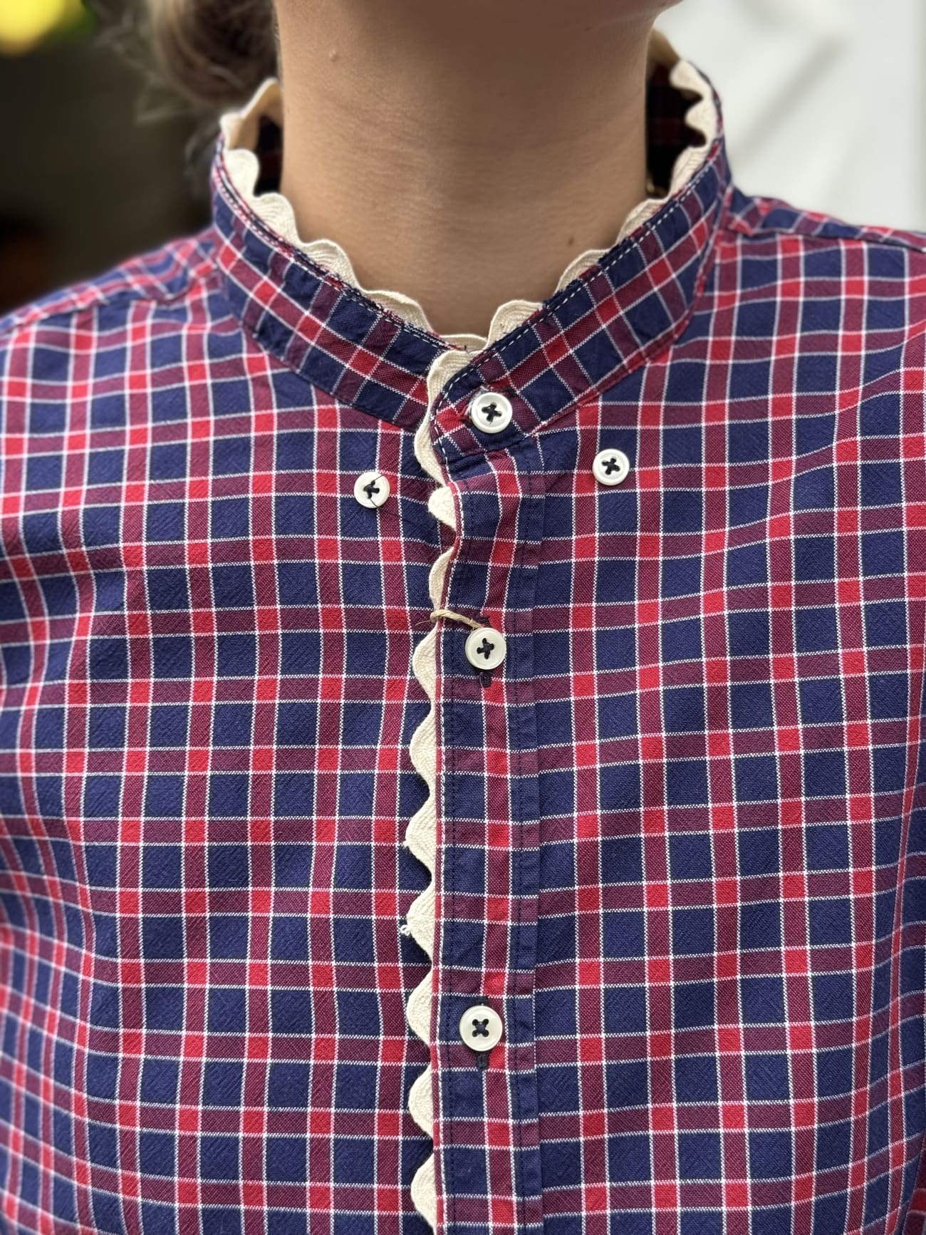 Détail motif écossais rouge & bleu et croquet blanc de la chemise