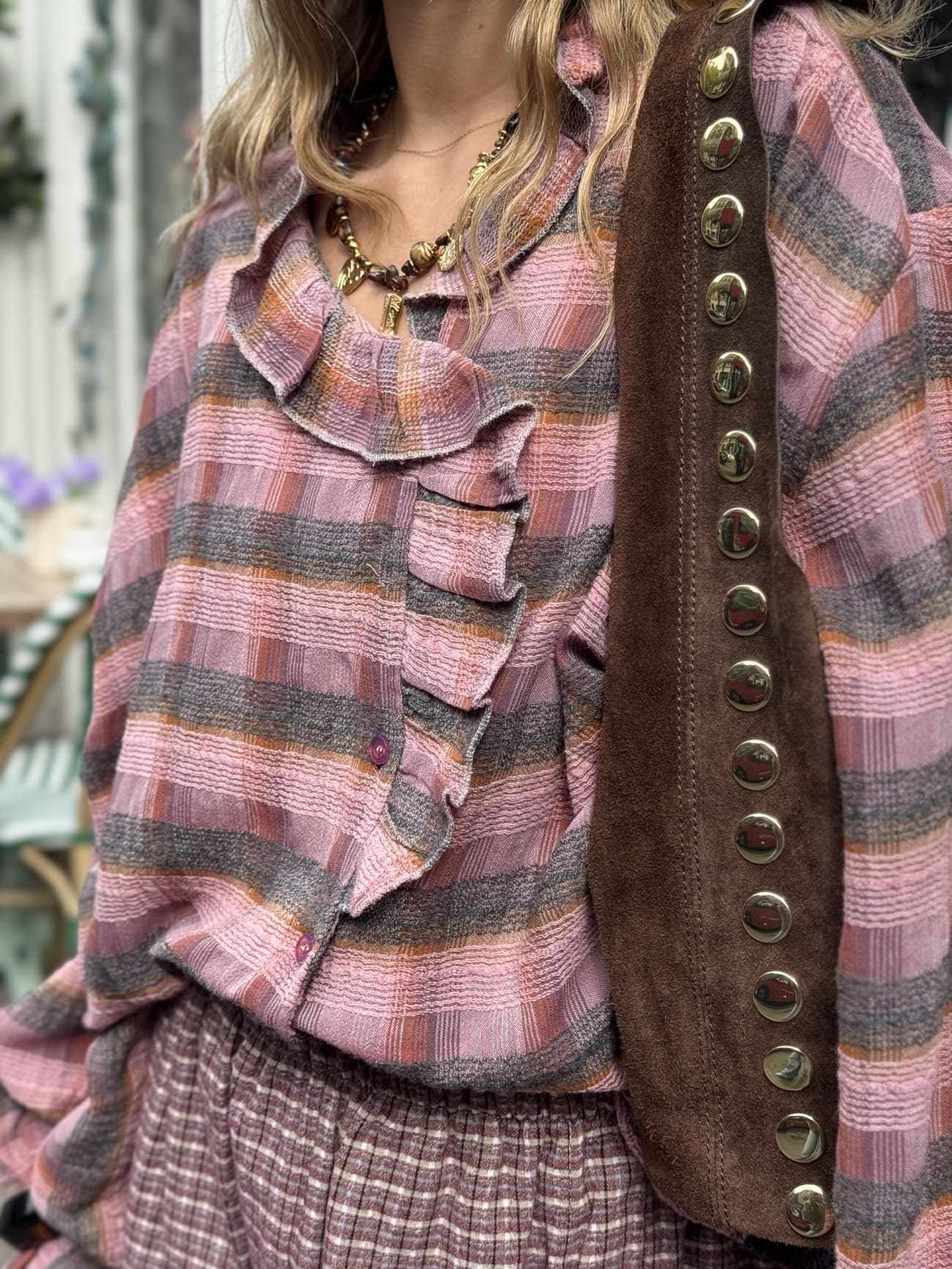 Femme portant la chemise rose et chocolat à volant.