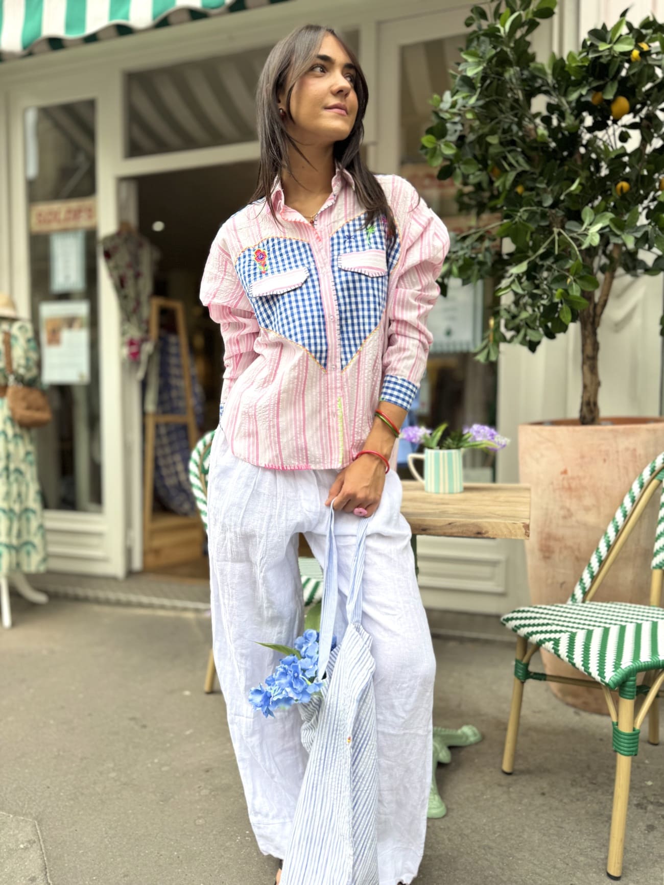 Chemise à rayures roses et incrustée de vichy bleu portée avec un pantalon blanc.