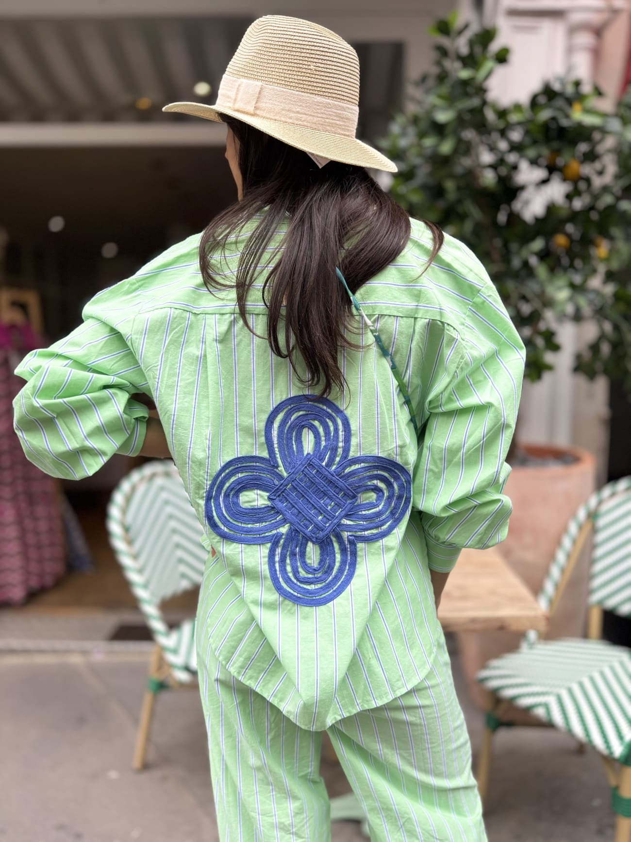 Détail de la broderie bleue sur chemise verte rayée