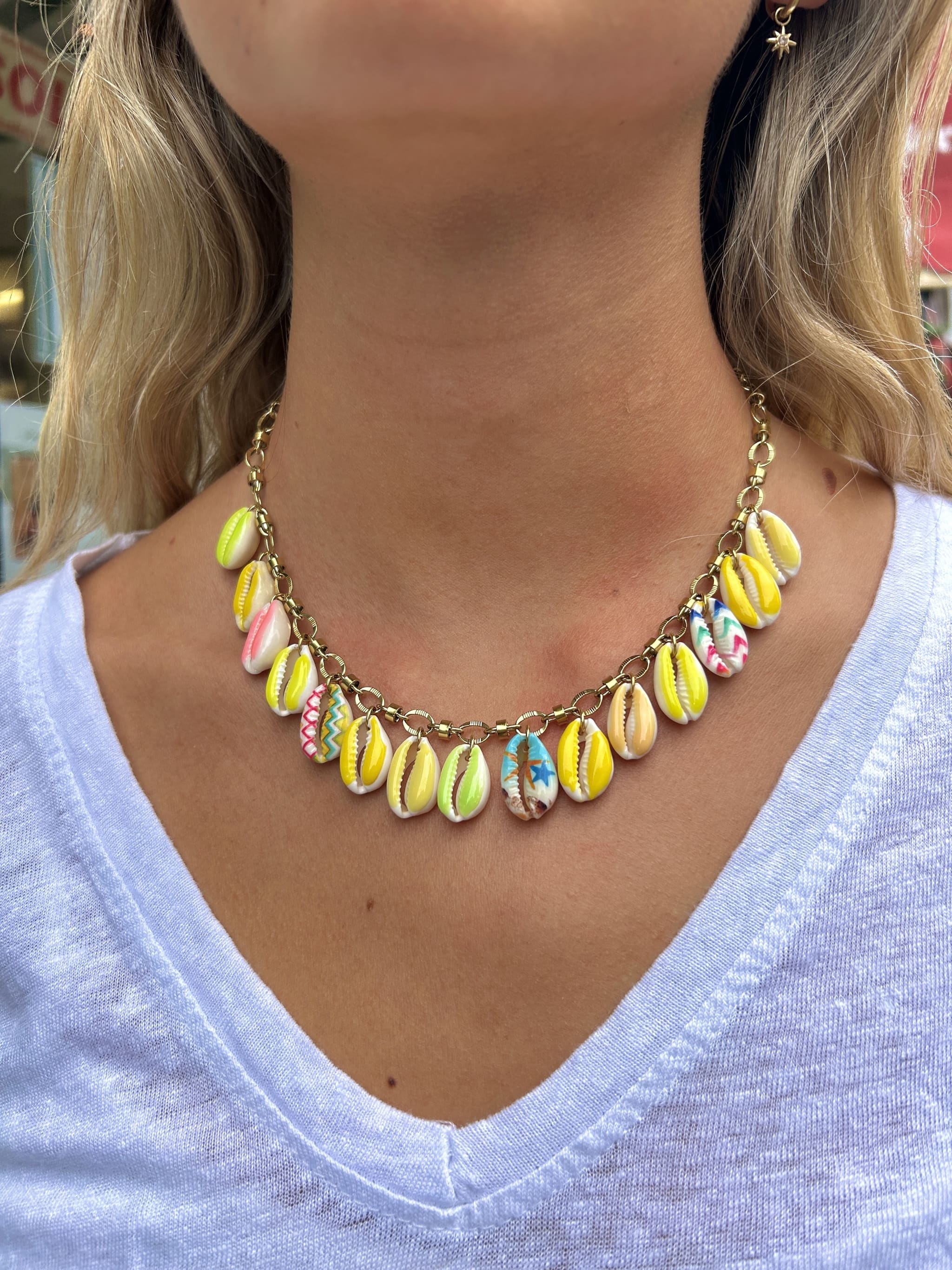 Collier Bahia avec breloques coquillage jaune et rose porté autour du cou 