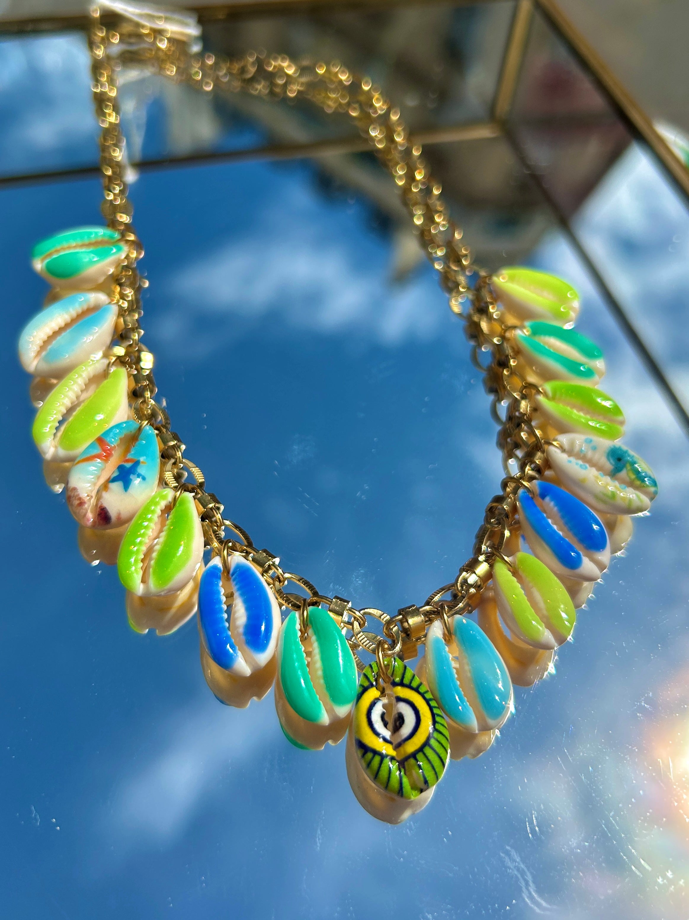 Gros plan des breloques coquillage vert et bleu