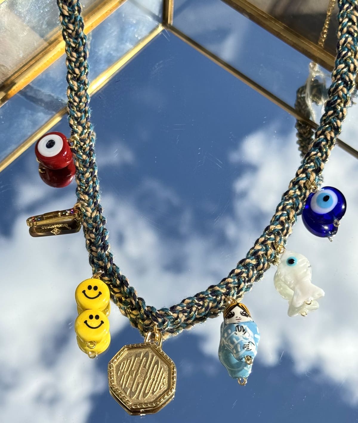 Gros plan du collier Kchoush bleu tressé avec ses 7 charms 
