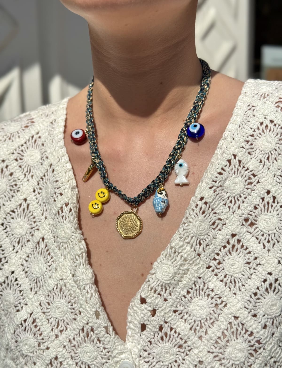 Collier Kchoush tressé bleu porté avec 7 charms symbolisant la guérison et l’énergie precious