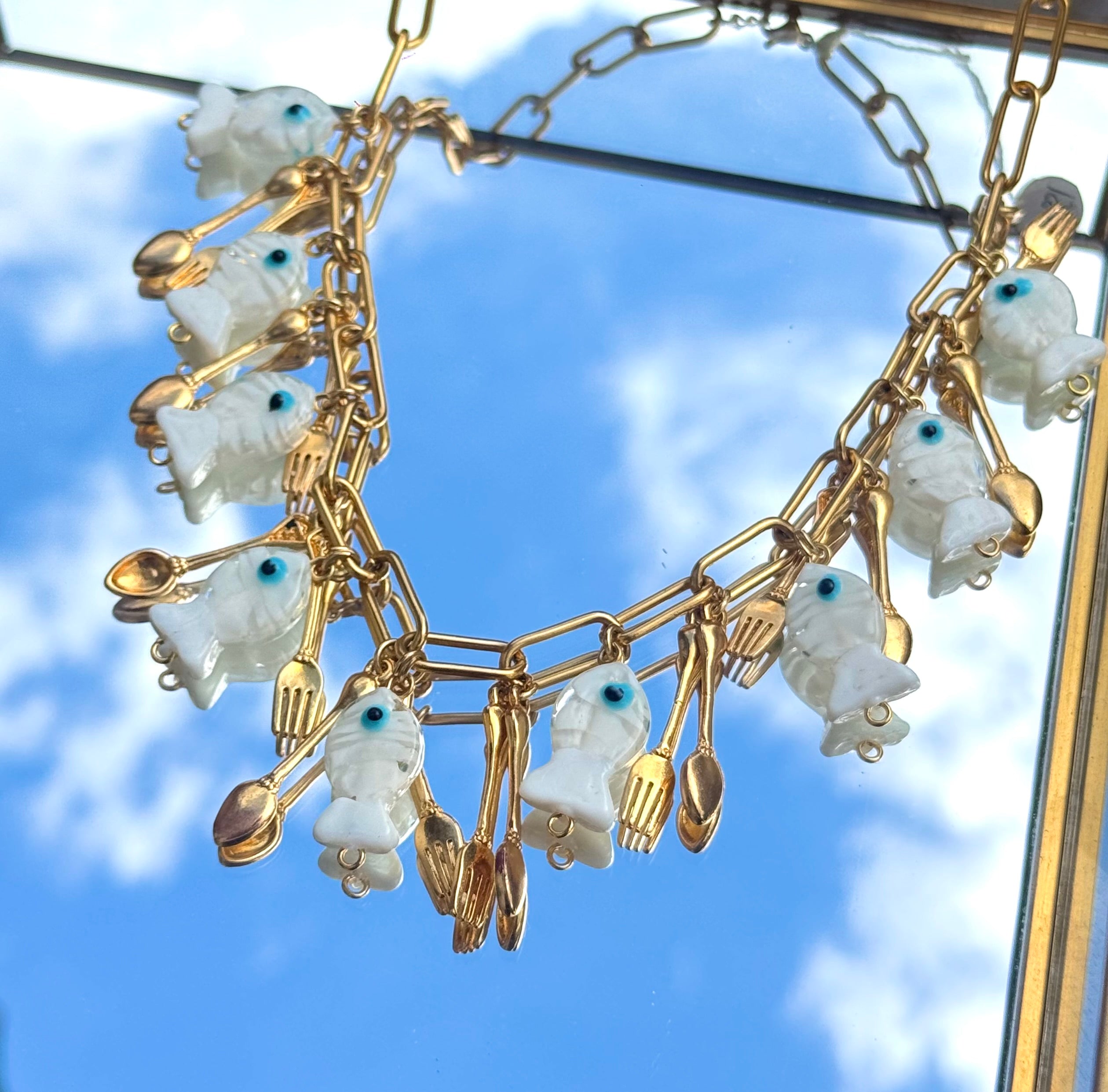 Gros plan du collier Kchoush avec breloque poisson et couvert