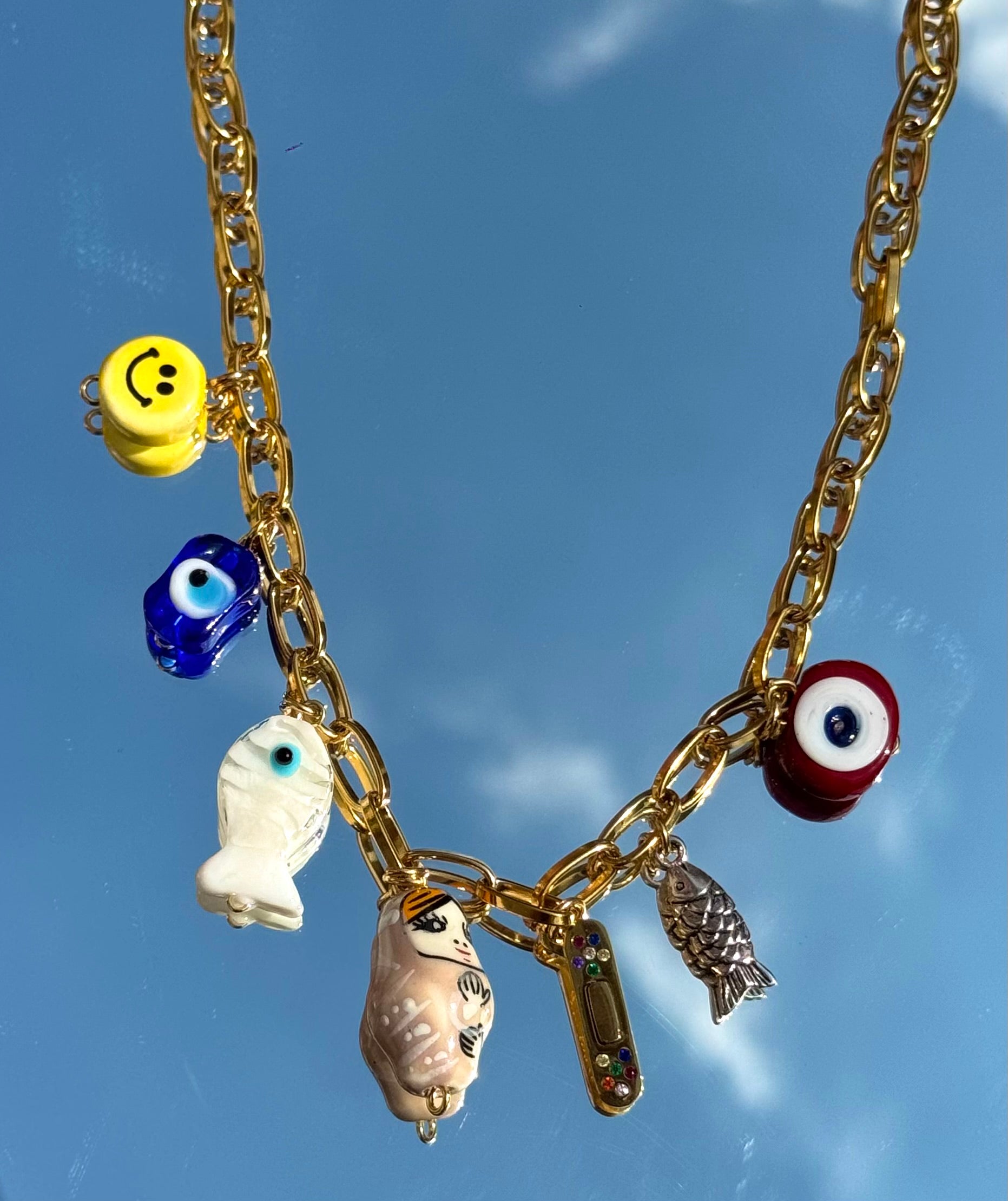 Détail du collier Mamie Colette – charms symbolisant la guérison, l'abondance et la protection