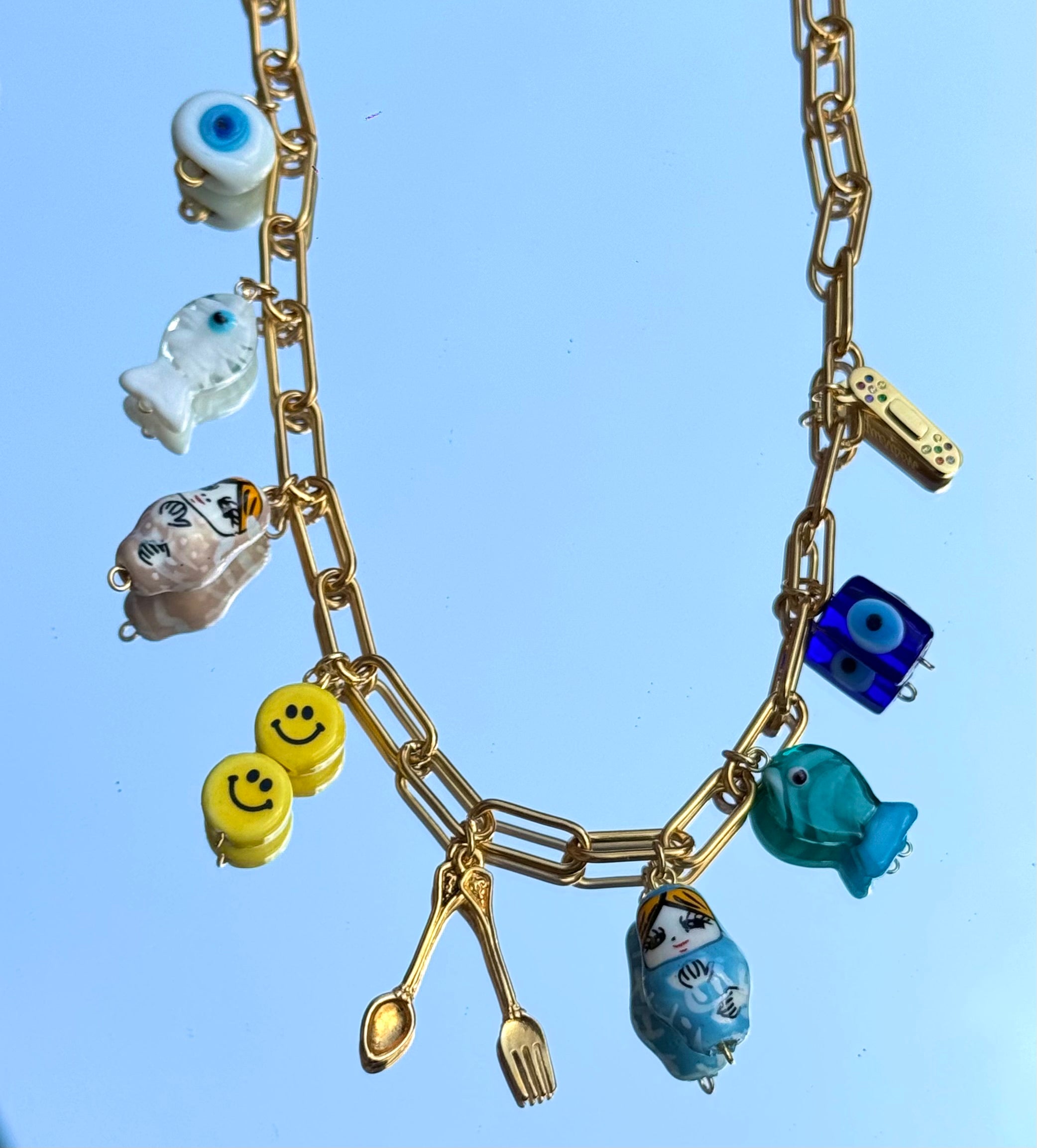 Gros plan sur les 9 charms du collier Mamie Esther – symboles de protection, chance et santé