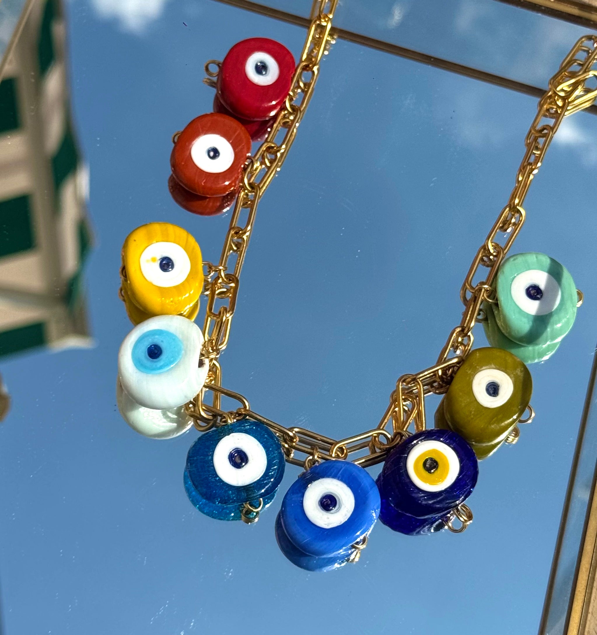 Gros plan sur les charms œil grec du collier Mamie Esther – symbole de protection