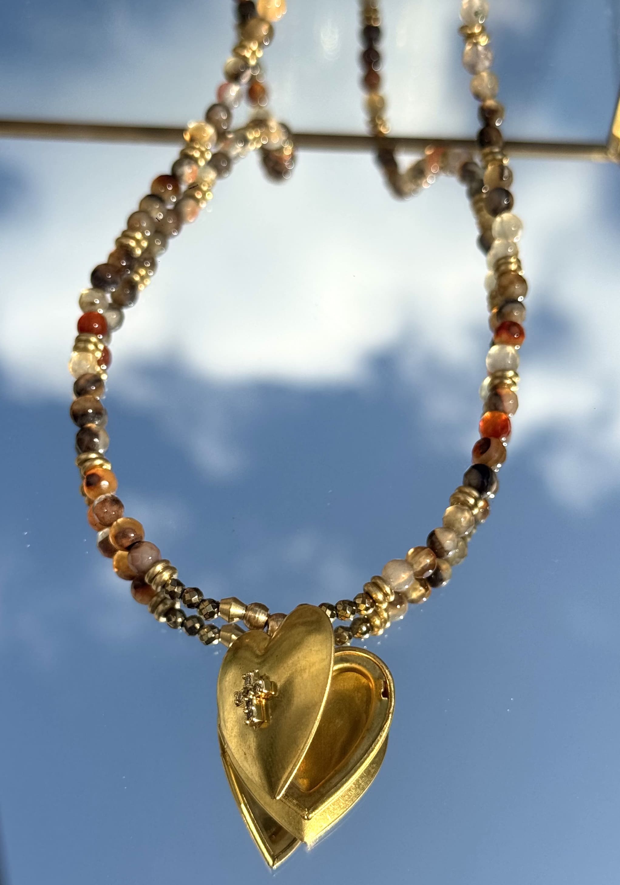 Gros plan sur le médaillon du collier MUKU Croix