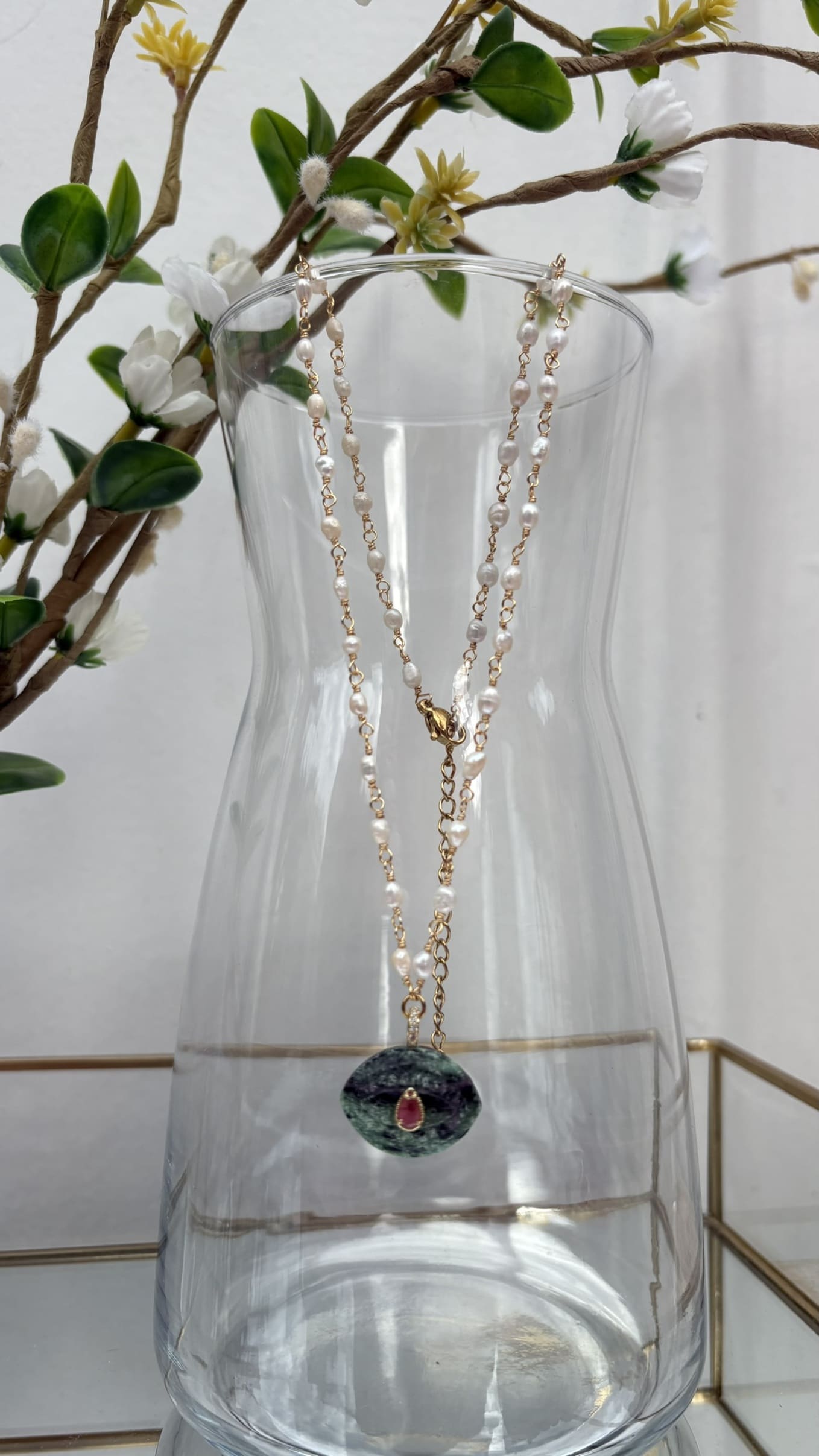 Collier en nacre et pierre d'agate verte suspendu à une carafe