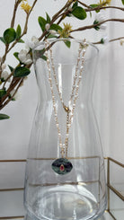 Collier en nacre et pierre d'agate verte suspendu à une carafe