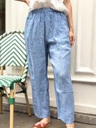 Gros plan sur la matière légère du pantalon en lin bleu jean, coupe moderne et naturelle