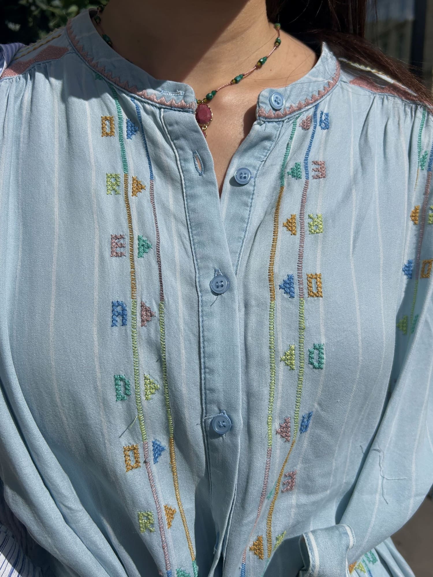 Détail de la poitrine brodée sur robe bleu ciel en viscose