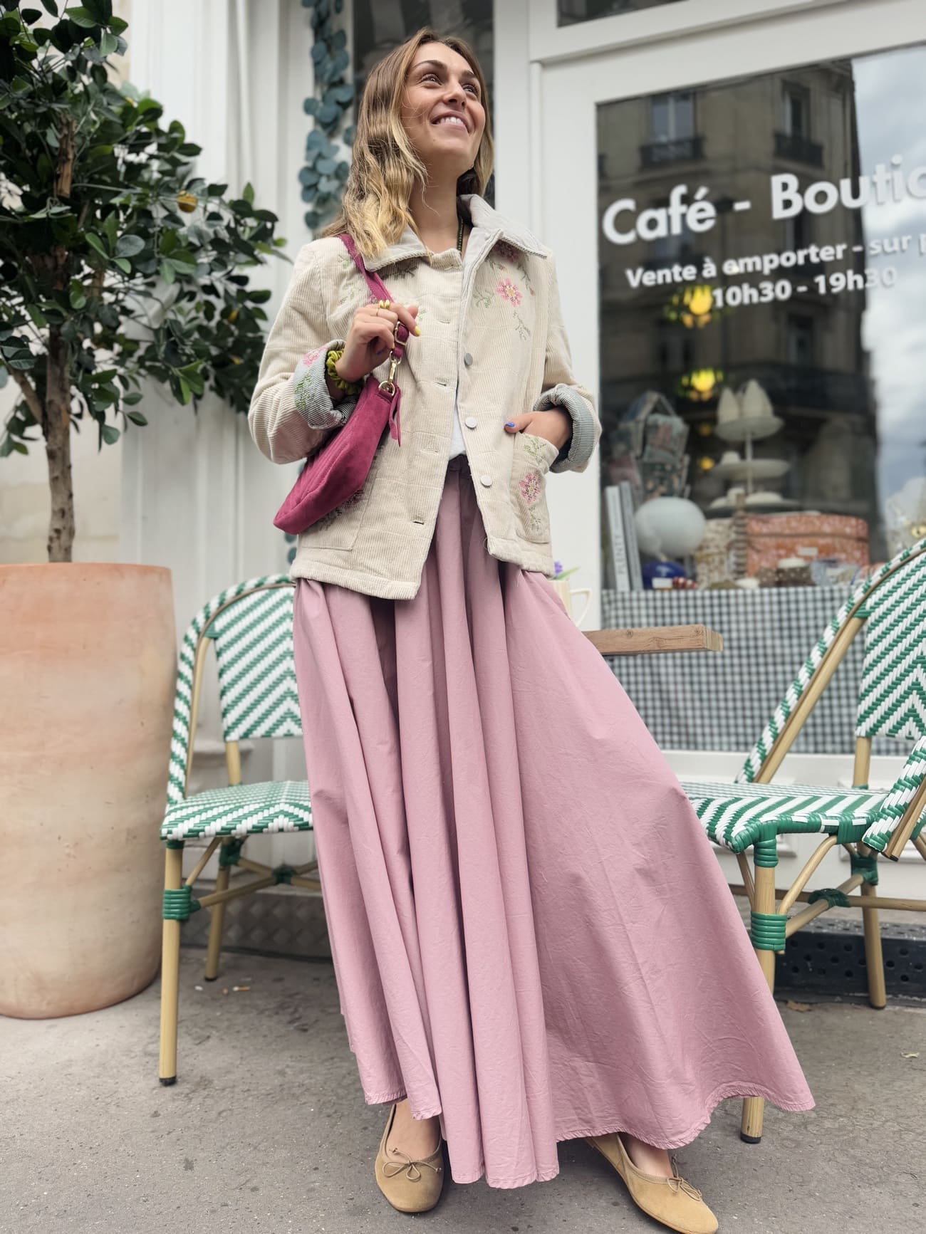 Femme debout portant une jupe longue forme corolle rose poudré