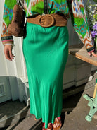 Détail du tissu satin vert émeraude de la jupe fluide