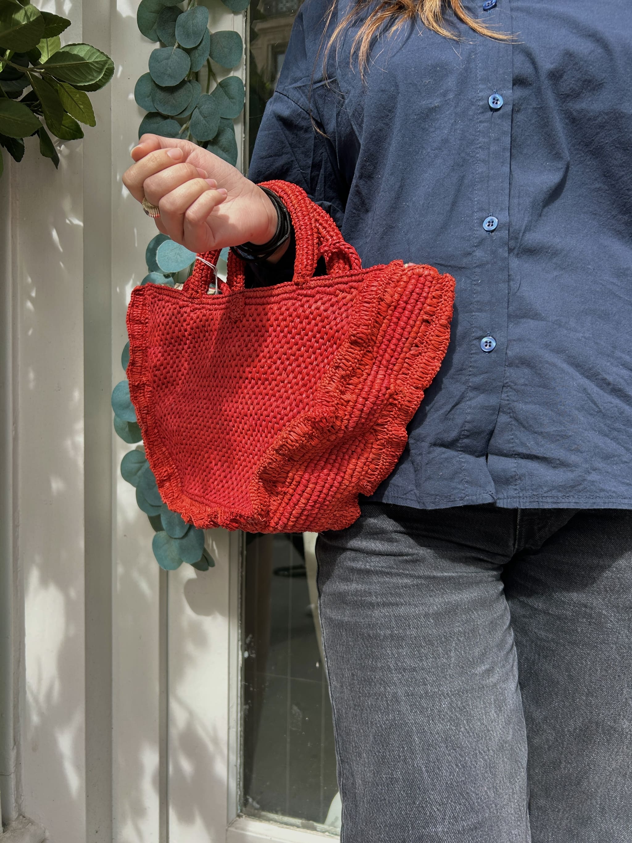 Panier rouge porté à la main, tressage artisanal
