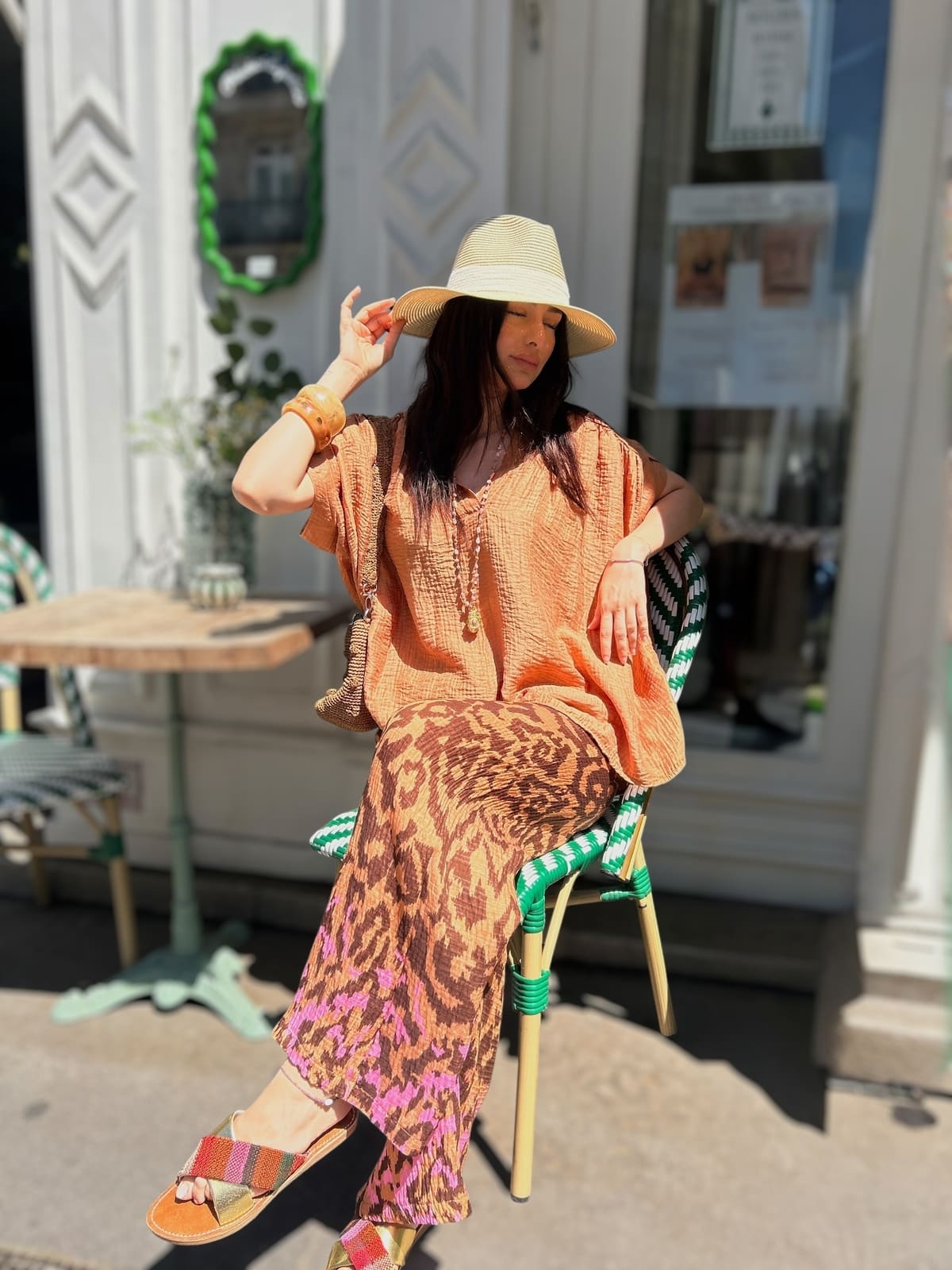 Détail rose en bas du pantalon fluide effet gaze de coton – femme assise