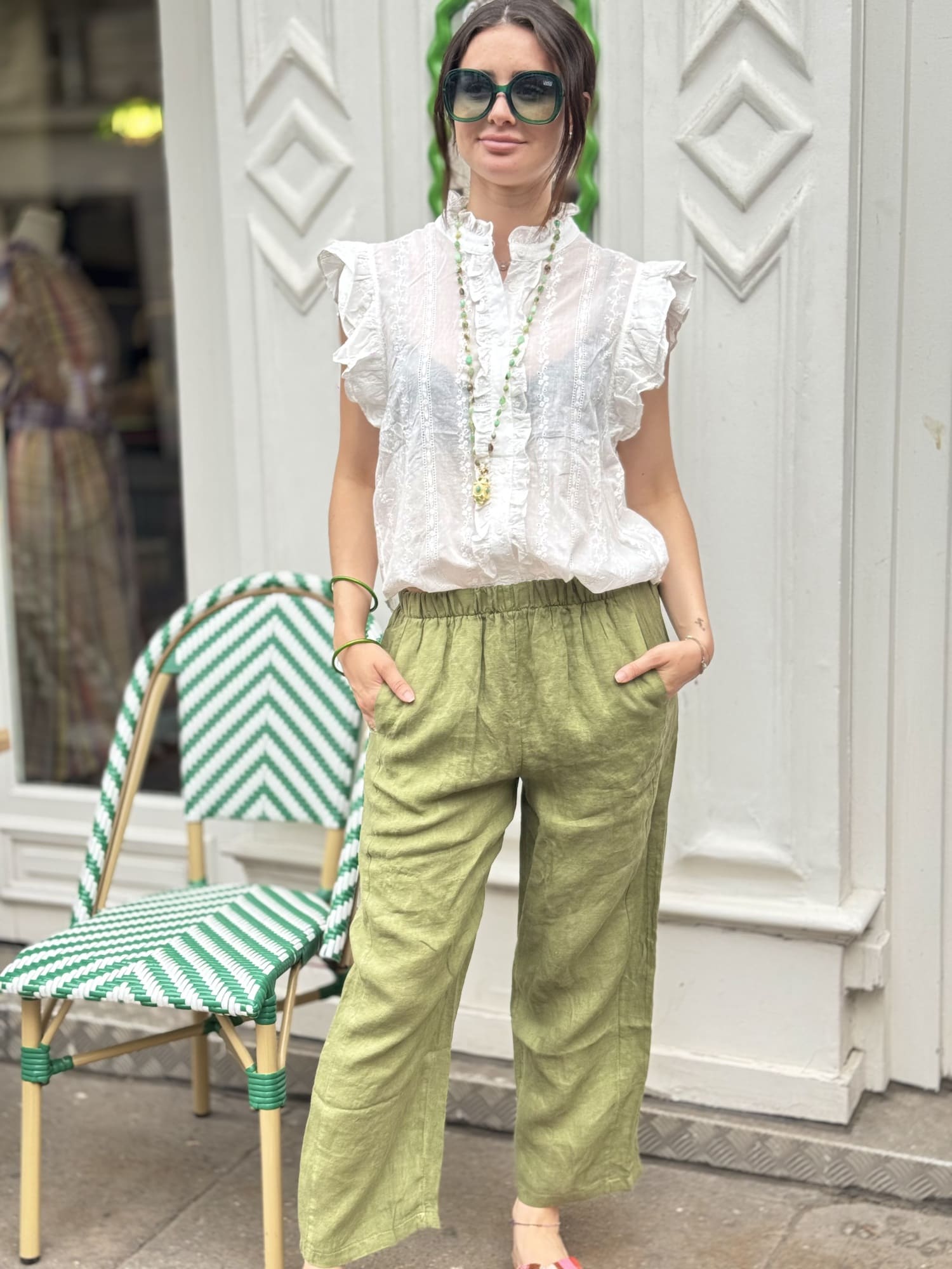 Femme portant un pantalon en lin kaki, coupe raccourcie, style chic et décontracté
