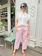Femme portant le pantalon rose poudré à motif bandana
